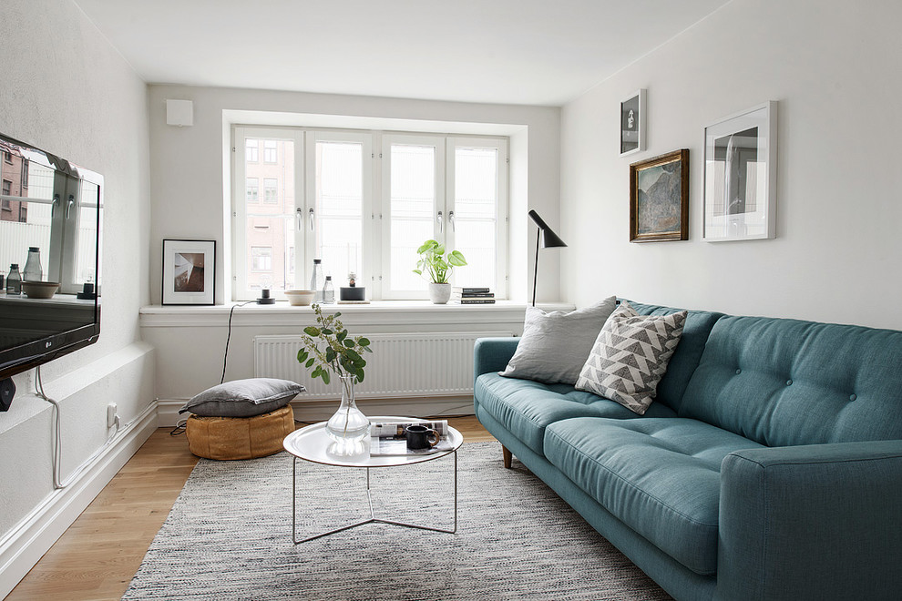 Идея дизайна: маленькая изолированная гостиная комната в скандинавском стиле с белыми стенами, светлым паркетным полом и телевизором на стене без камина для на участке и в саду
