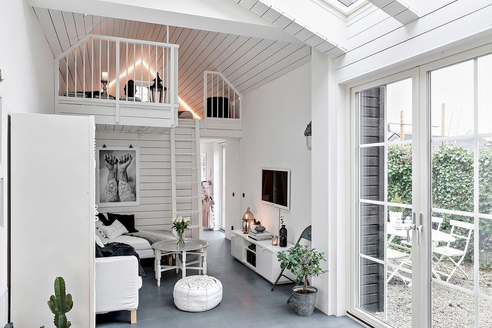 マルメにある小さな北欧スタイルのおしゃれなオープンリビング (白い壁、壁掛け型テレビ、グレーの床、コンクリートの床) の写真