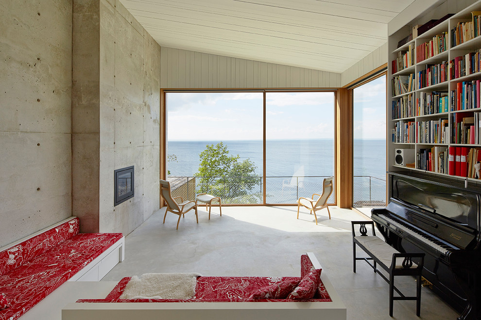 Immagine di un grande soggiorno design aperto con libreria, pavimento in cemento, camino lineare Ribbon, pareti grigie e nessuna TV