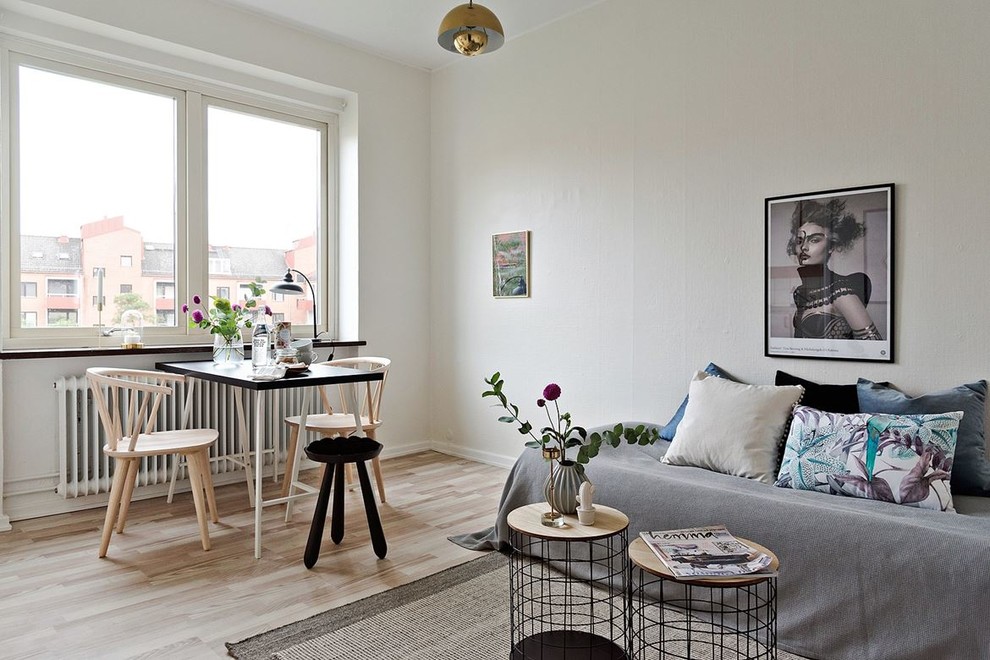 Immagine di un soggiorno scandinavo di medie dimensioni con pareti bianche, parquet chiaro e pavimento beige