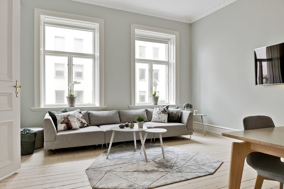 Idées déco pour une salle de séjour scandinave de taille moyenne avec un mur gris, parquet clair et un sol beige.
