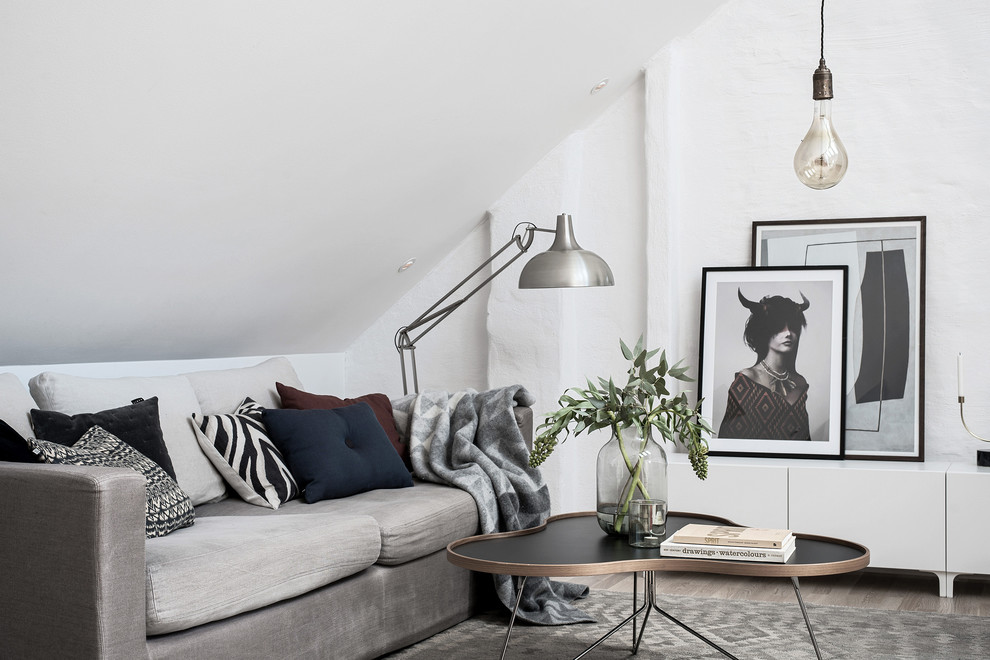 Aménagement d'une salle de séjour scandinave avec un mur blanc, parquet clair et un sol beige.