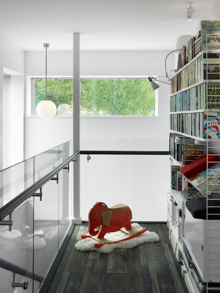 Idéer för ett modernt allrum på loftet, med vita väggar, mörkt trägolv och ett bibliotek