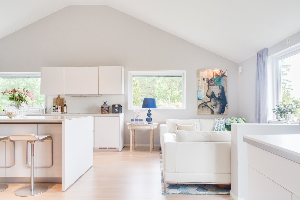 Imagen de sala de estar abierta escandinava de tamaño medio con paredes blancas, suelo de madera clara y suelo beige
