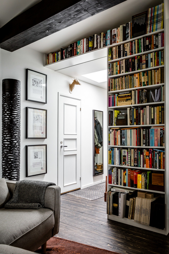Diseño de sala de estar con biblioteca cerrada nórdica de tamaño medio con paredes blancas y suelo de madera oscura