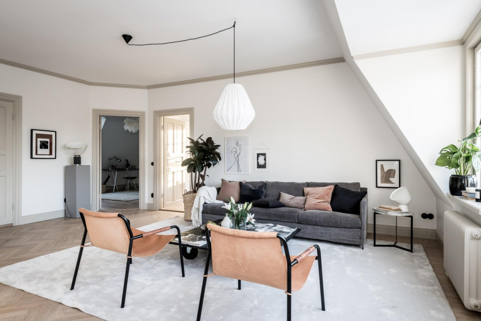 Esempio di un soggiorno scandinavo con pareti bianche, pavimento in legno massello medio e pavimento marrone