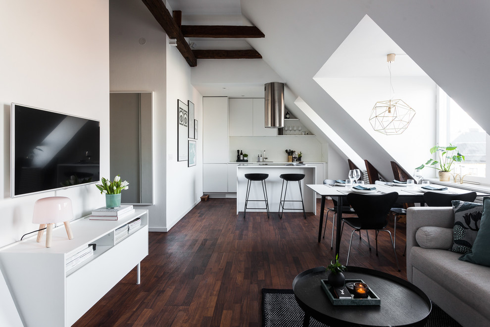 Mittelgroßes, Offenes Skandinavisches Wohnzimmer ohne Kamin mit beiger Wandfarbe, dunklem Holzboden und TV-Wand in Stockholm