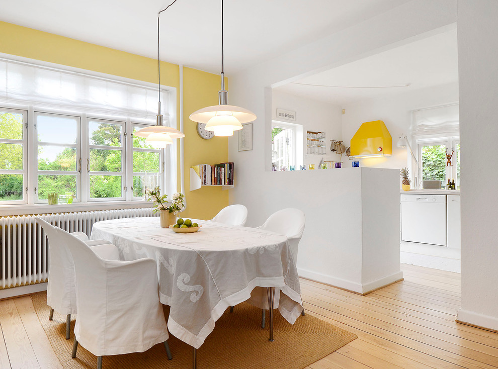 Идея дизайна: столовая в скандинавском стиле с желтыми стенами и паркетным полом среднего тона