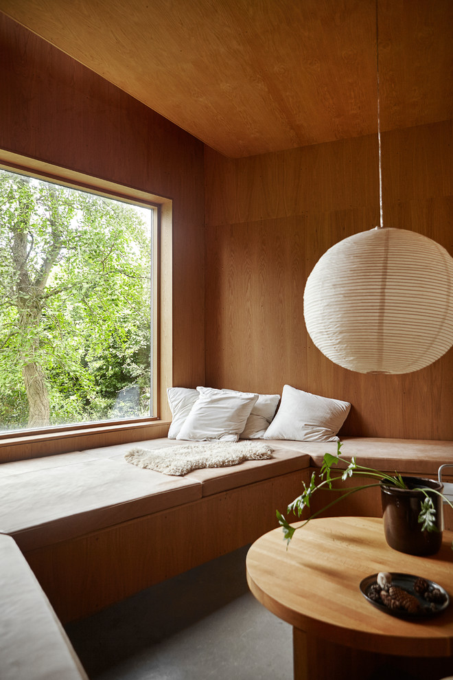 Mittelgroßes, Abgetrenntes Modernes Wohnzimmer mit brauner Wandfarbe, Betonboden und grauem Boden in Aarhus