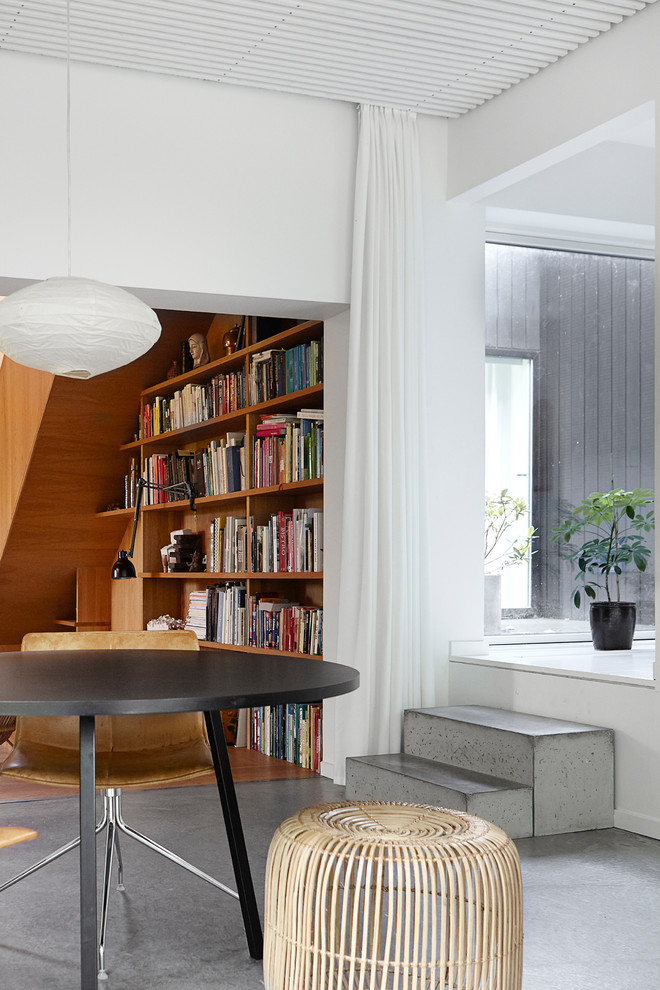 Großes Modernes Wohnzimmer mit weißer Wandfarbe und Betonboden in Aarhus