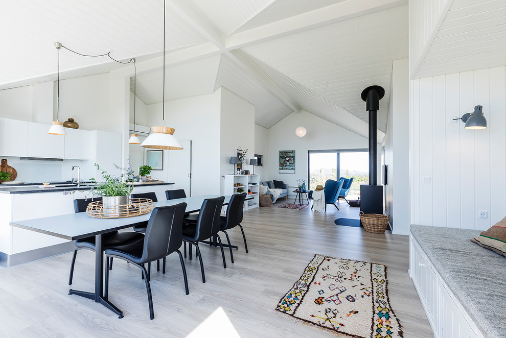 Mittelgroßes, Offenes Skandinavisches Wohnzimmer mit weißer Wandfarbe, hellem Holzboden, Kaminofen und braunem Boden in Sonstige