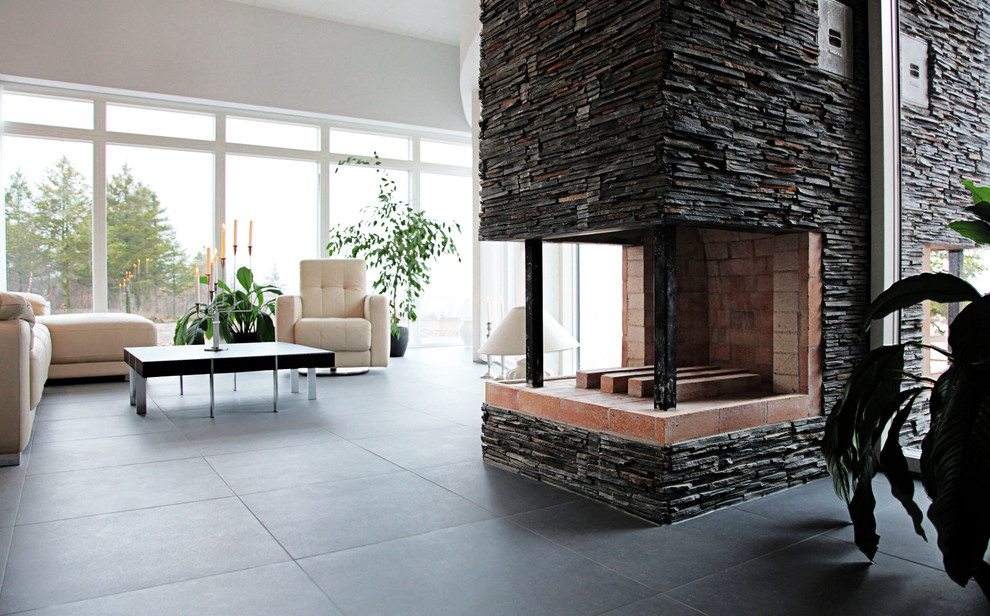 Источник вдохновения для домашнего уюта: гостиная комната в современном стиле с белыми стенами, полом из сланца, двусторонним камином, фасадом камина из кирпича и черным полом