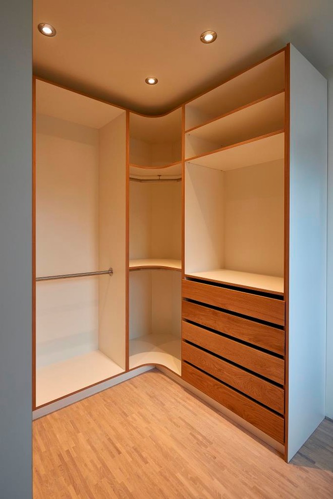 Стильный дизайн: гардеробная комната среднего размера в современном стиле с открытыми фасадами, светлым паркетным полом и коричневым полом - последний тренд