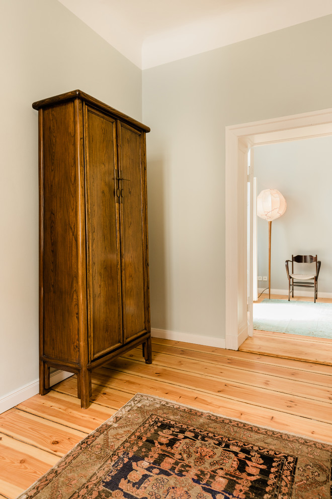 Foto de vestidor unisex bohemio de tamaño medio con puertas de armario de madera en tonos medios y suelo de madera clara