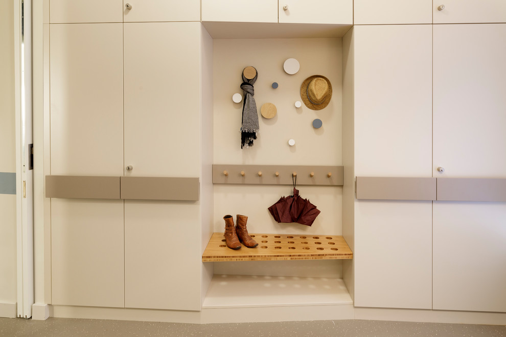 Diseño de vestidor unisex nórdico de tamaño medio con armarios con paneles lisos, puertas de armario blancas, suelo de linóleo y suelo beige