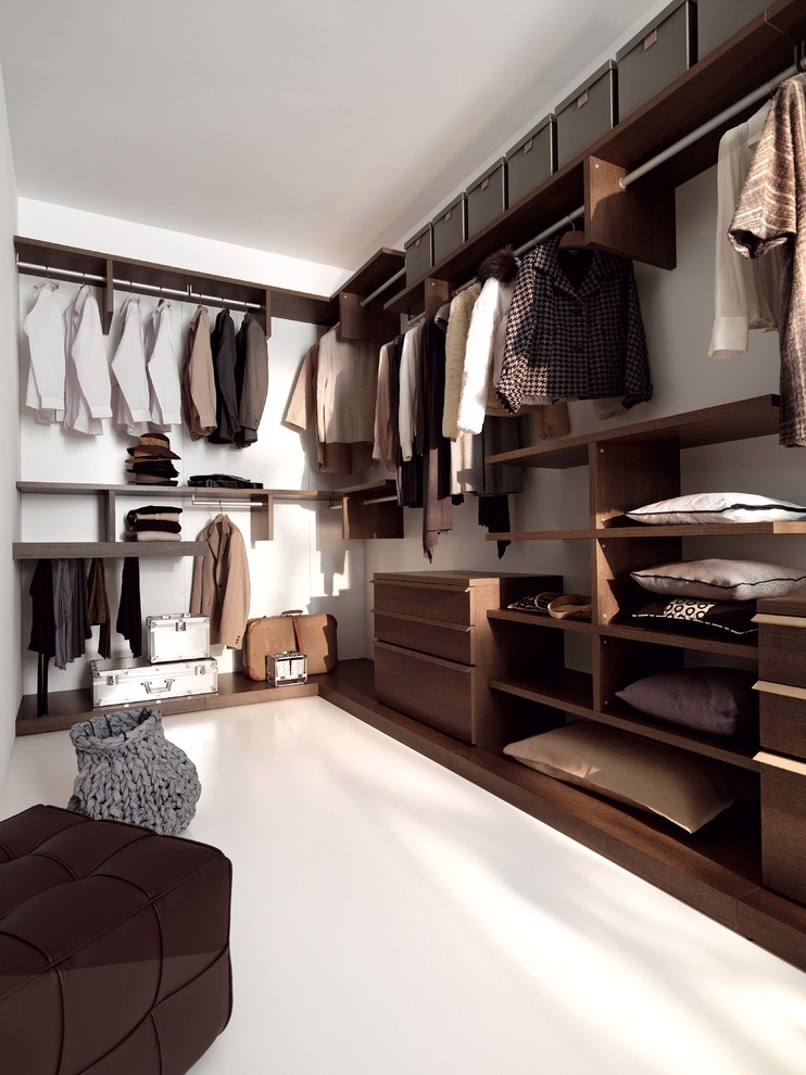 Ejemplo de armario vestidor unisex actual grande con armarios con paneles lisos, puertas de armario de madera en tonos medios, suelo de cemento y suelo blanco