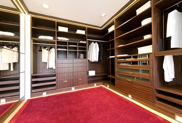 Пример оригинального дизайна: большая гардеробная комната унисекс в классическом стиле с открытыми фасадами, темными деревянными фасадами и ковровым покрытием