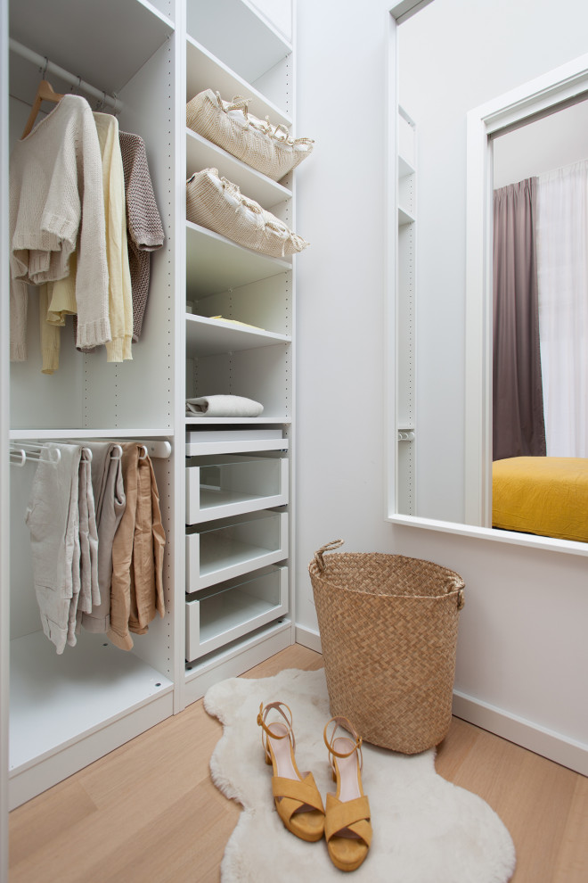 Inspiration pour un petit dressing room bohème neutre avec un placard sans porte, des portes de placard blanches, parquet clair et un sol beige.