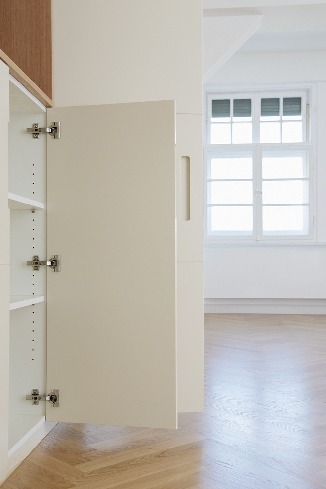 Foto de vestidor unisex contemporáneo extra grande con armarios con paneles lisos, puertas de armario beige, suelo de madera clara y suelo beige