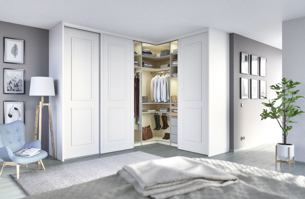 Ejemplo de armario unisex contemporáneo pequeño con armarios con paneles con relieve, puertas de armario blancas, suelo de madera clara y suelo gris