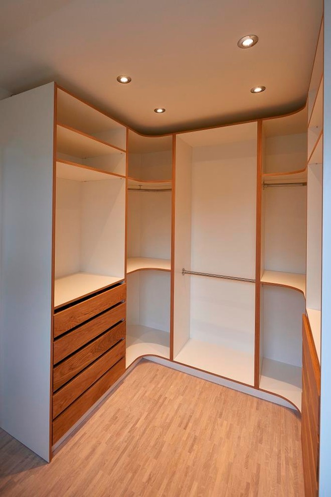 Imagen de armario vestidor contemporáneo de tamaño medio con armarios abiertos, suelo de madera clara y suelo marrón