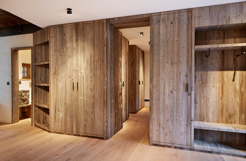 Idee per una cabina armadio unisex stile rurale di medie dimensioni con ante lisce, ante in legno scuro, parquet chiaro e pavimento beige