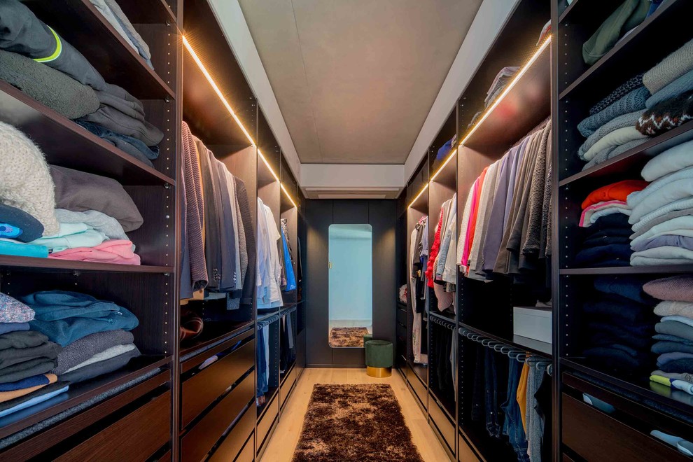Foto de armario vestidor unisex minimalista de tamaño medio con armarios abiertos, suelo de madera en tonos medios y suelo beige