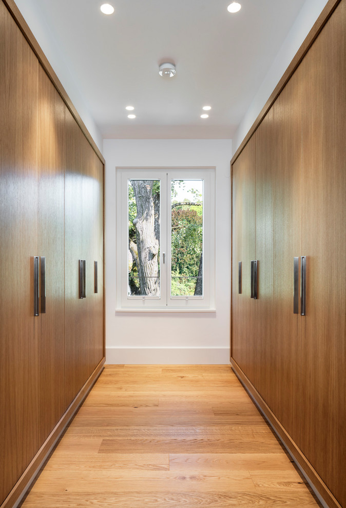 Idées déco pour un grand dressing moderne en bois brun neutre avec un placard à porte plane, un sol en bois brun et un sol marron.