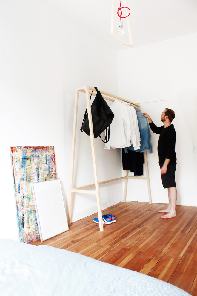 Diseño de armario y vestidor unisex moderno pequeño con suelo de madera en tonos medios