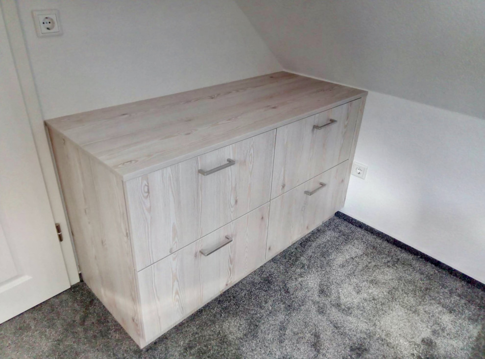 Réalisation d'une armoire encastrée nordique en bois clair avec un placard à porte plane, moquette et un sol gris.