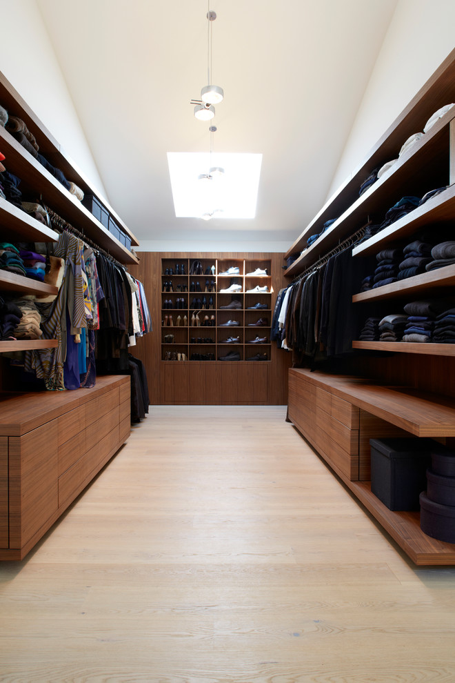 Design ideas for a medium sized modern gender neutral walk-in wardrobe in Munich with open cabinets, brown cabinets and light hardwood flooring.