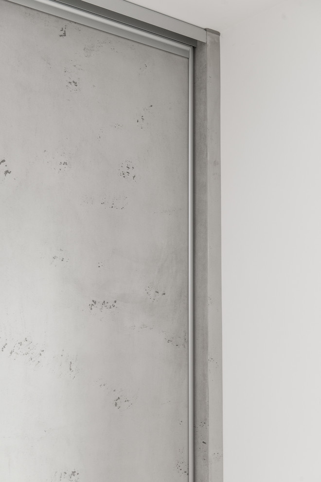 Geräumiges, Neutrales Modernes Ankleidezimmer mit Ankleidebereich, flächenbündigen Schrankfronten, grauen Schränken, hellem Holzboden und braunem Boden in München
