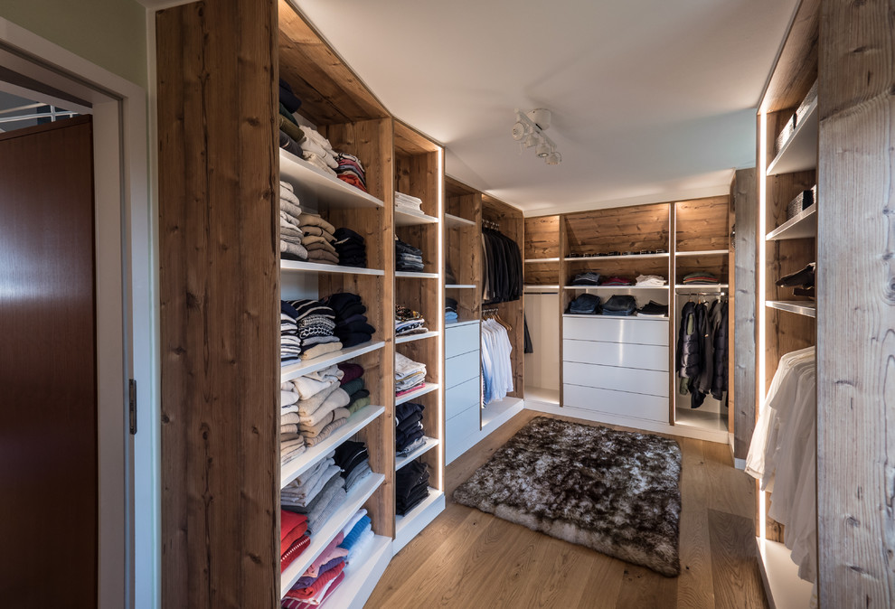 Ejemplo de armario vestidor unisex rústico de tamaño medio con armarios abiertos, puertas de armario de madera oscura, suelo de madera en tonos medios y suelo marrón