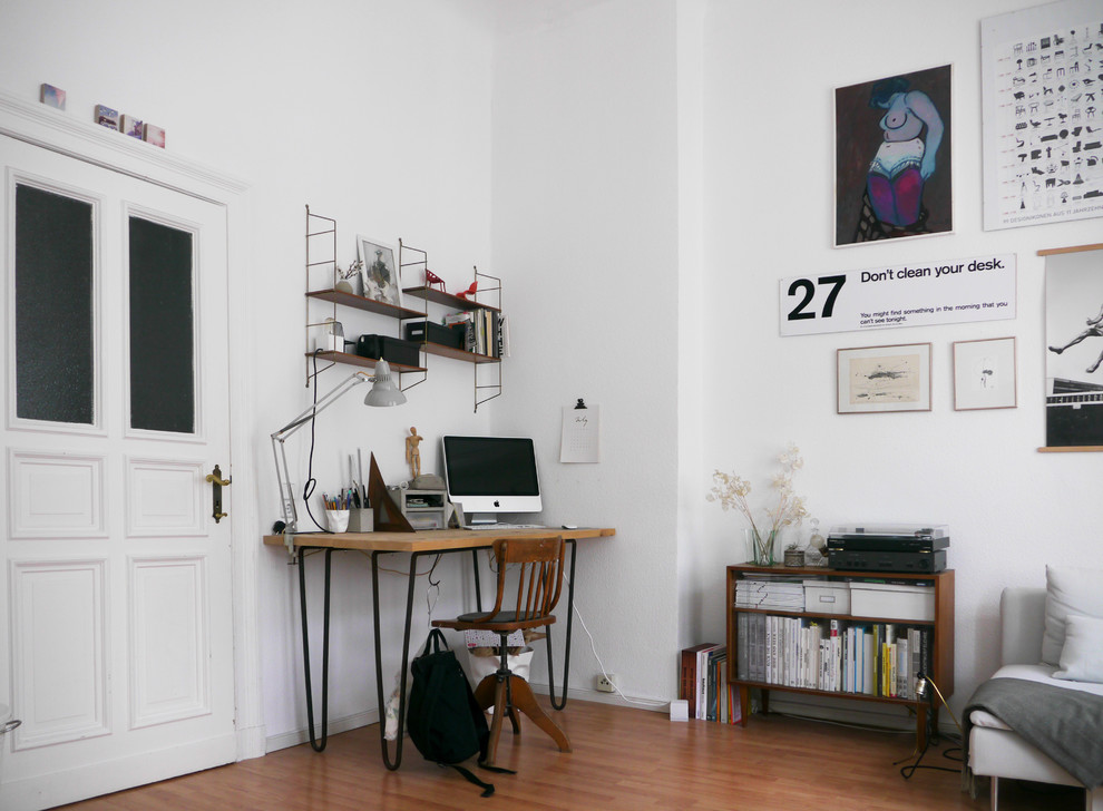 ベルリンにある広いおしゃれな書斎 (白い壁、無垢フローリング、暖炉なし、自立型机、茶色い床) の写真