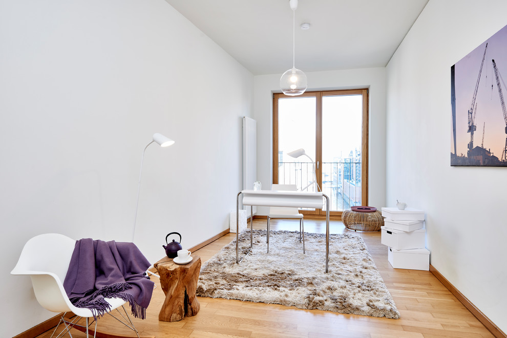 Réalisation d'un bureau nordique de taille moyenne avec un mur blanc, un sol en bois brun, un bureau indépendant et un sol marron.