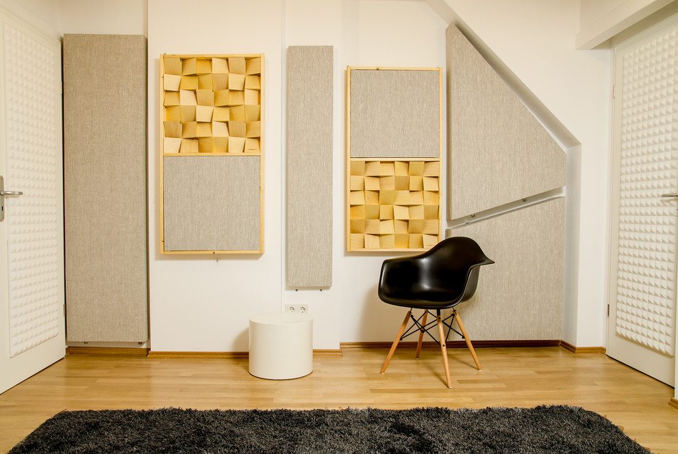 Mittelgroßes Modernes Arbeitszimmer ohne Kamin mit Studio, weißer Wandfarbe, braunem Holzboden und braunem Boden in Berlin