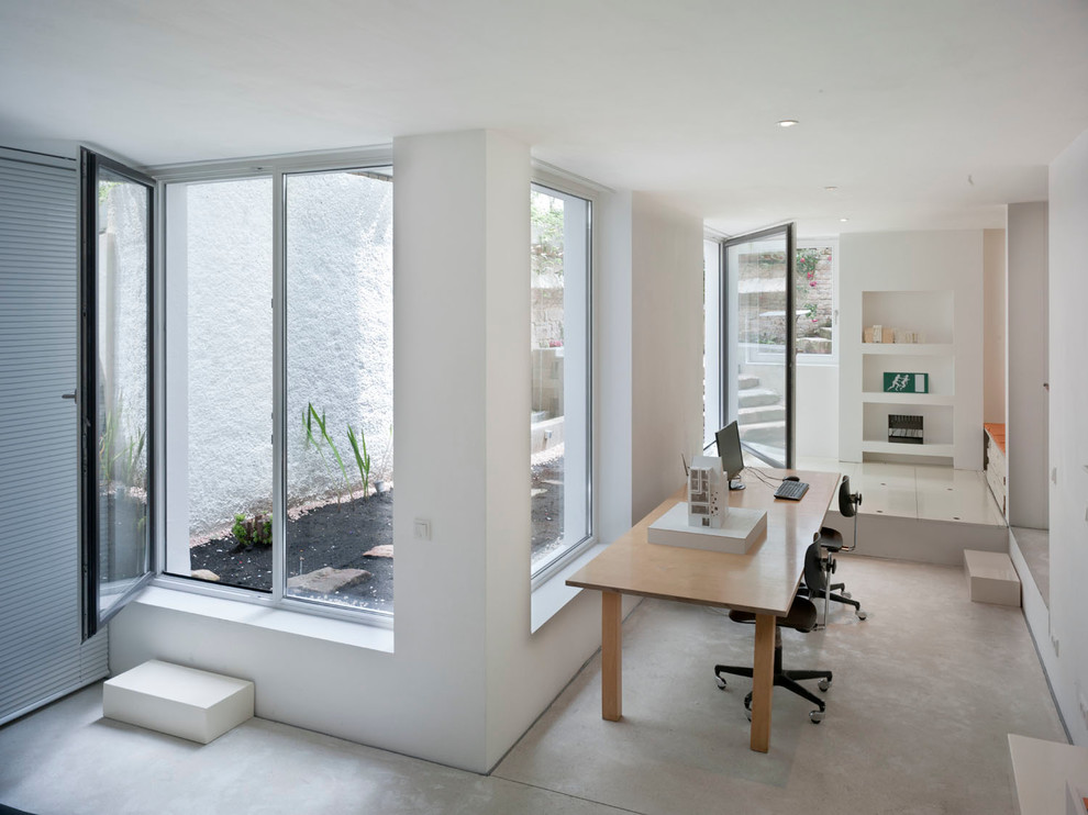 Kleines Modernes Arbeitszimmer ohne Kamin mit Arbeitsplatz, weißer Wandfarbe und freistehendem Schreibtisch in Frankfurt am Main