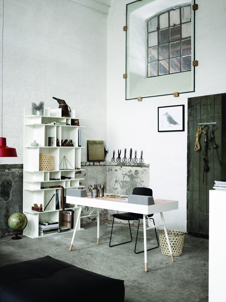 Стильный дизайн: рабочее место в современном стиле с белыми стенами, бетонным полом и отдельно стоящим рабочим столом без камина - последний тренд