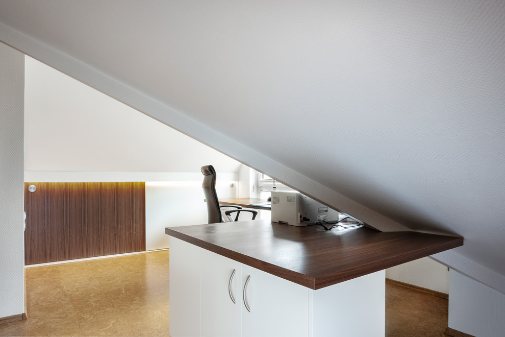 Esempio di un ufficio design di medie dimensioni con pareti bianche, pavimento in sughero, scrivania incassata e pavimento marrone