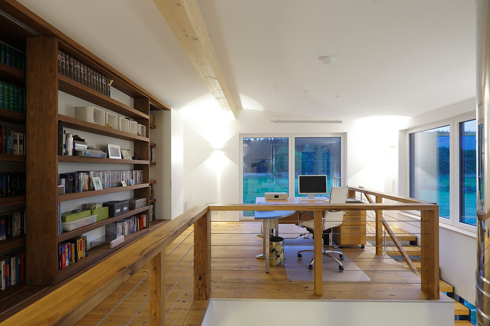 Cette photo montre un bureau tendance de taille moyenne avec un mur blanc, un sol en bois brun, aucune cheminée et un bureau indépendant.