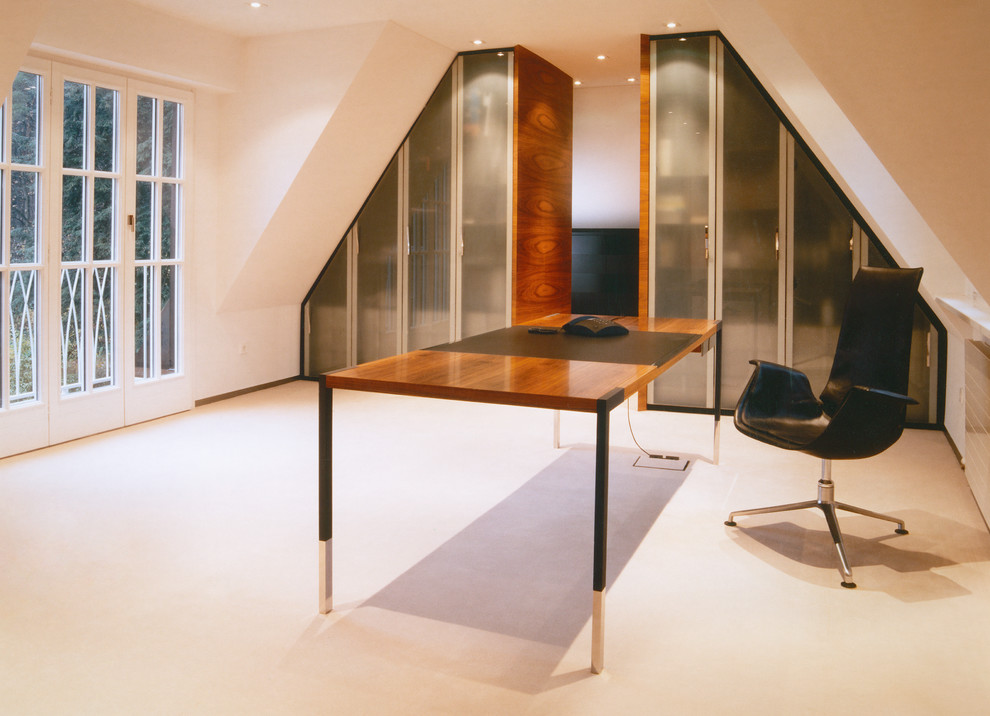 Großes Modernes Arbeitszimmer ohne Kamin mit Arbeitsplatz, weißer Wandfarbe, Teppichboden und freistehendem Schreibtisch in Nürnberg