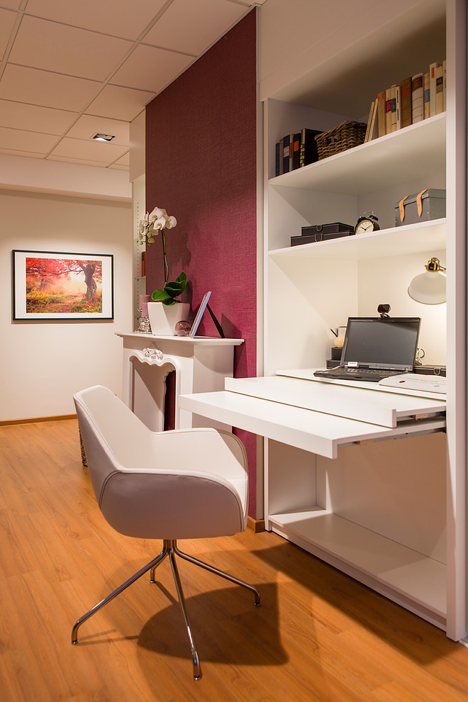 Cette image montre un bureau design de type studio avec un mur blanc, parquet clair, un bureau intégré et une cheminée standard.