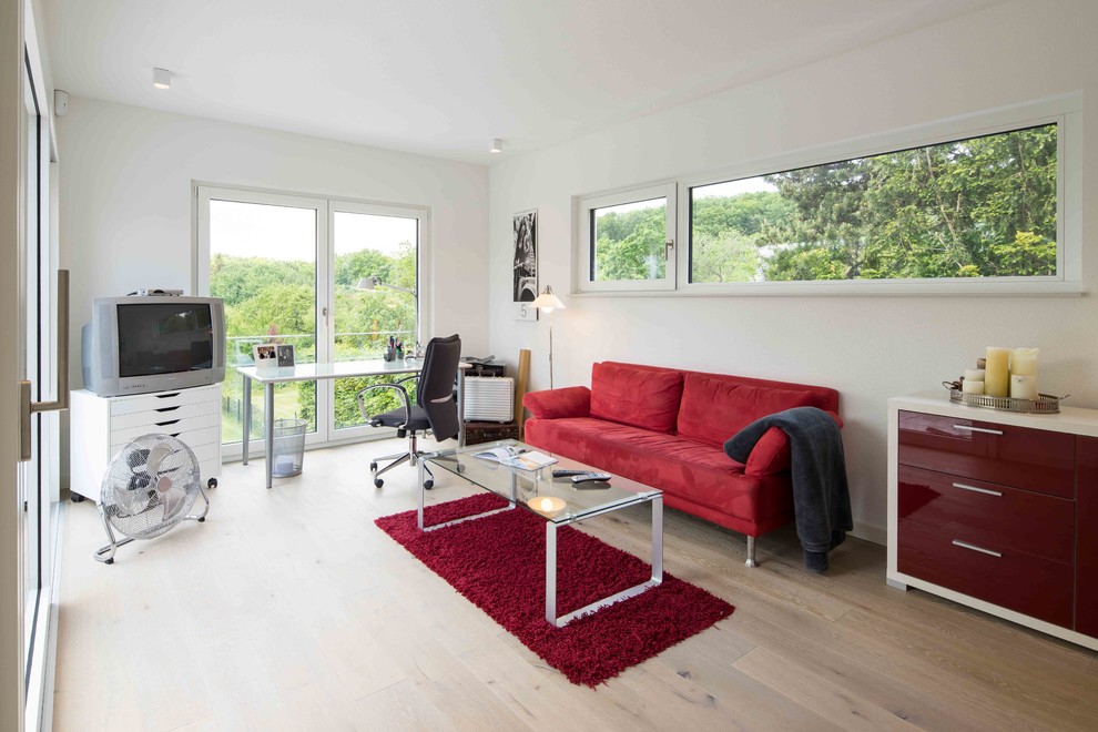 Imagen de despacho actual de tamaño medio con paredes blancas, suelo de madera clara, escritorio independiente y suelo marrón