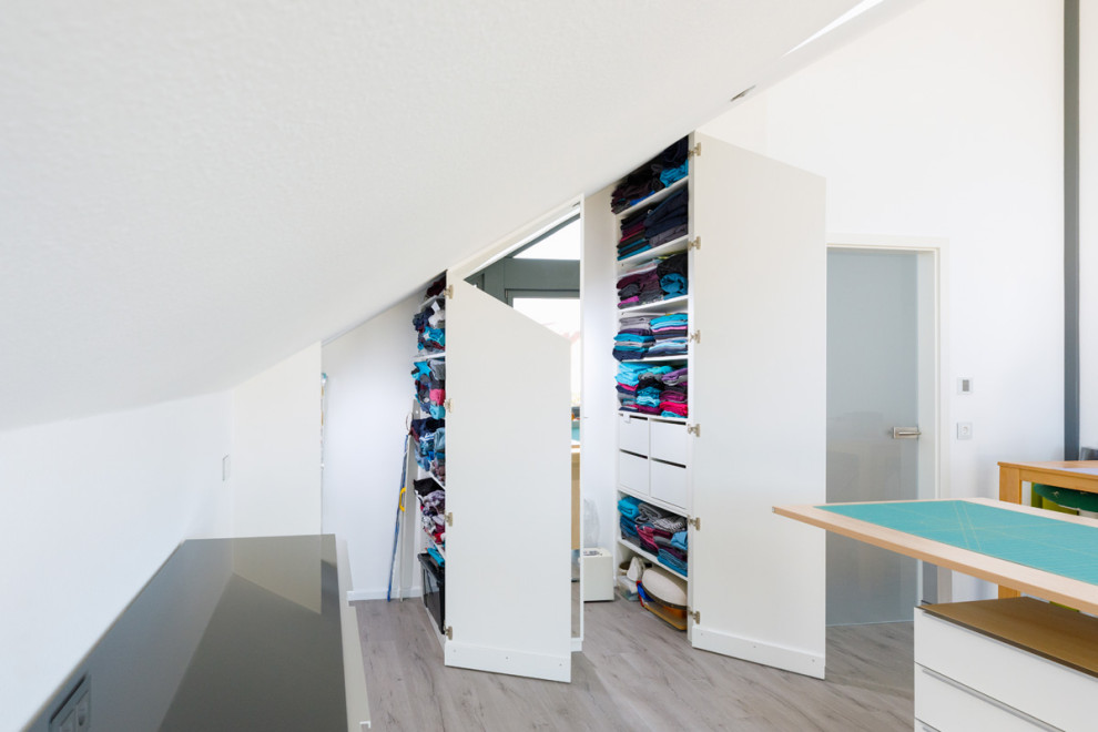 Foto de sala de manualidades minimalista de tamaño medio con paredes blancas, suelo laminado y suelo beige