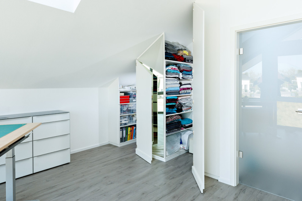Photo of a medium sized modern craft room in Stuttgart with white walls, laminate floors and beige floors.