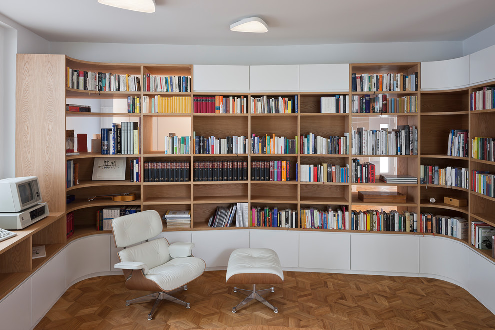 Mittelgroßes Modernes Lesezimmer ohne Kamin mit weißer Wandfarbe, braunem Holzboden und braunem Boden in Berlin