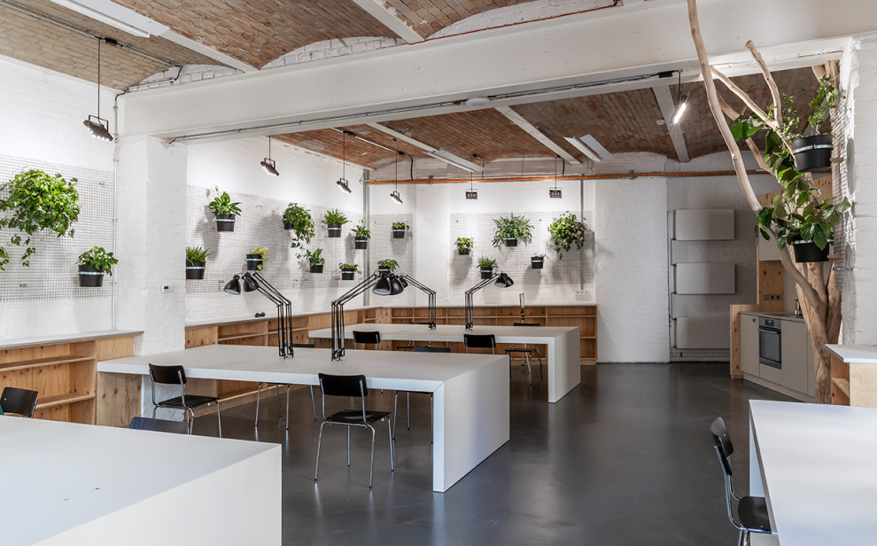 Пример оригинального дизайна: рабочее место среднего размера в стиле модернизм с белыми стенами, полом из линолеума, встроенным рабочим столом, серым полом, сводчатым потолком и кирпичными стенами
