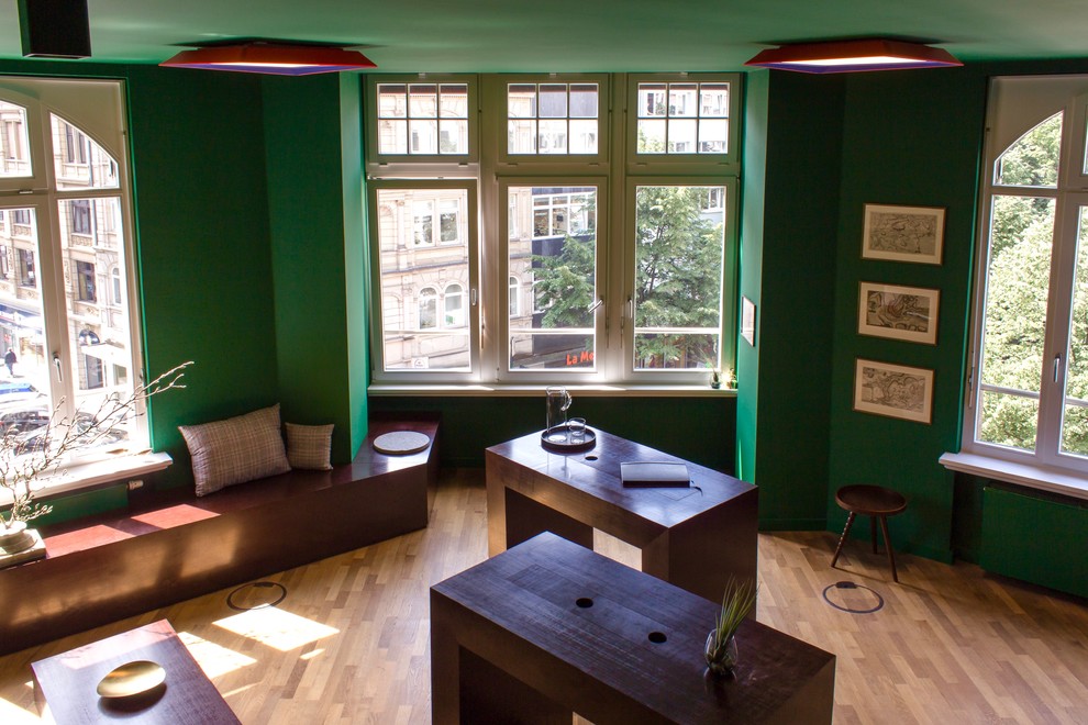 Medium sized contemporary study in Frankfurt with green walls, medium hardwood flooring and brown floors.
