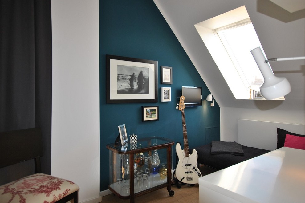 Modelo de despacho actual de tamaño medio sin chimenea con paredes azules, suelo de madera oscura, escritorio independiente y suelo beige