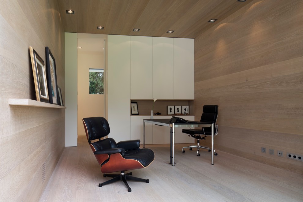 Mittelgroßes Modernes Arbeitszimmer mit Arbeitsplatz, hellem Holzboden, freistehendem Schreibtisch und brauner Wandfarbe in Hamburg